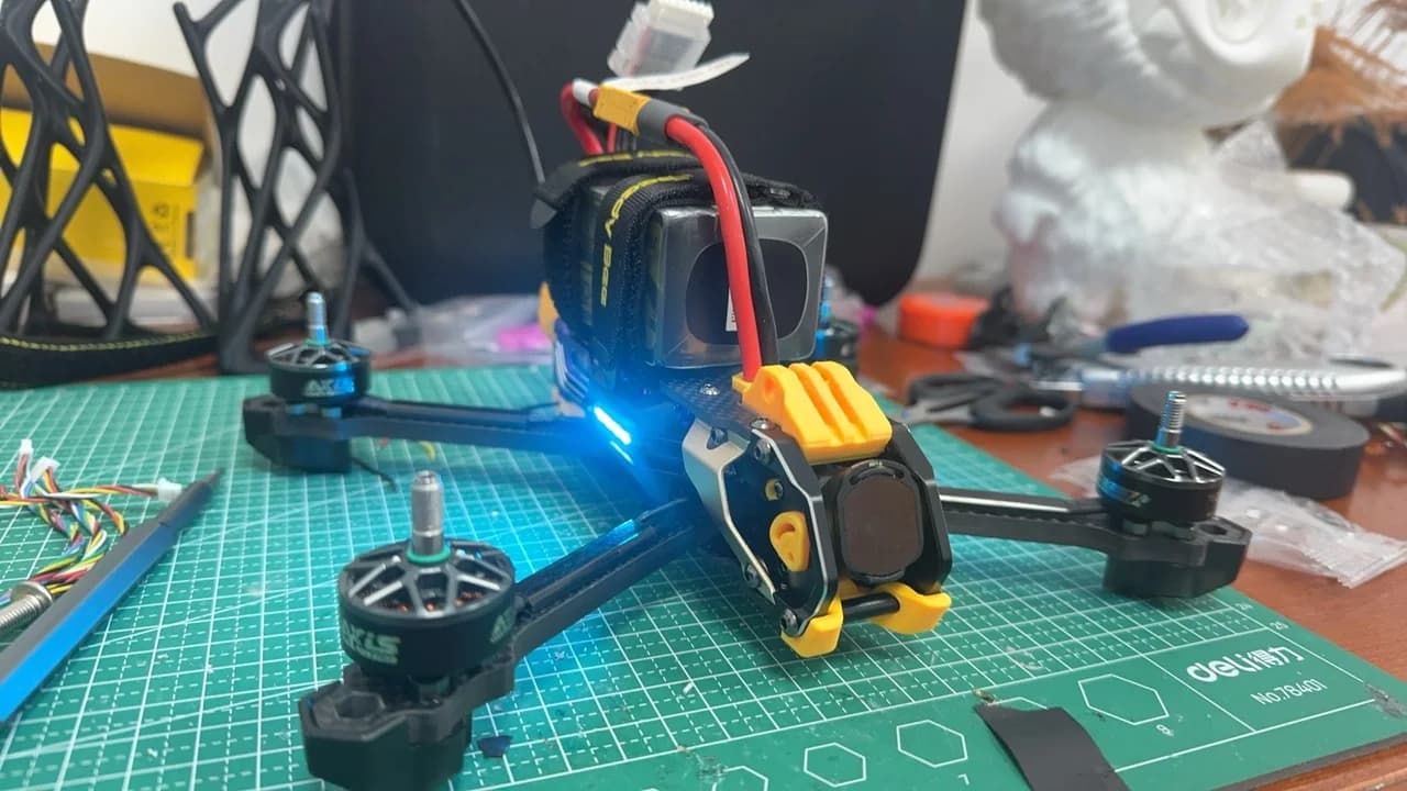 Custom FPV drone with front camera and battery mount assembled on a workbench